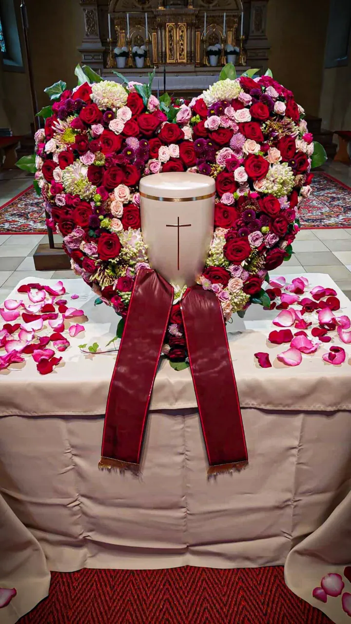 Herzförmiges Blumenarrangement mit Urne, Bestattung Himmelsfalter