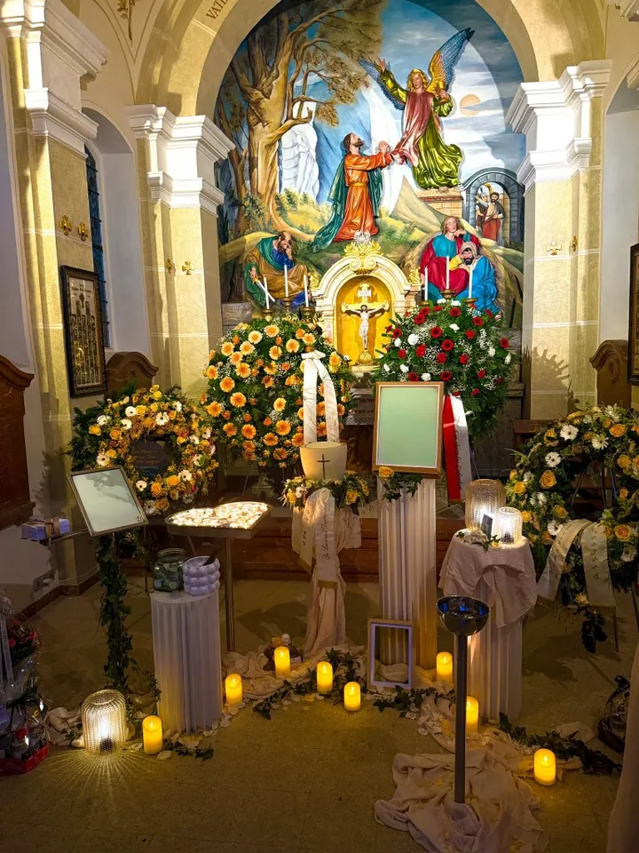 Würdevoll gestaltete Aufbahrung mit Blumen und Kerzen in einer Kirche, Bestattung Himmelsfalter